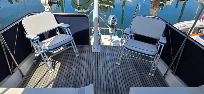 Grand Finale Yacht Photos Pics Deck seating area on a 1991 Grand Banks 36 Classic yacht, featuring two white chairs.