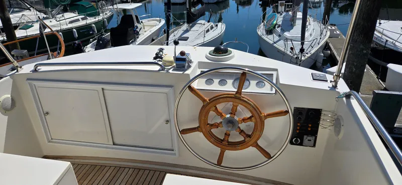 Grand Finale Yacht Photos Pics Helm of 1991 Grand Banks 36 Classic yacht with wooden wheel, docked at marina.