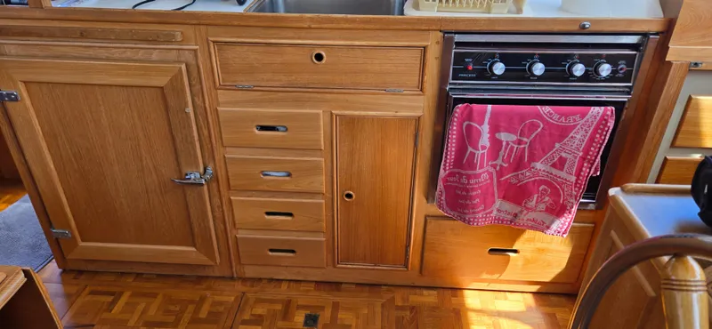 Grand Finale Yacht Photos Pics Wooden kitchen interior of 1991 Grand Banks 36 Classic boat with stove and red towel.