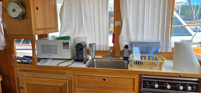 Grand Finale Yacht Photos Pics Interior of 1991 Grand Banks 36 Classic yacht kitchen with appliances and wooden cabinetry.