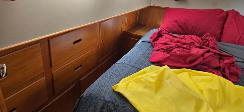 Grand Finale Yacht Photos Pics Cozy cabin interior of 1991 Grand Banks 36 Classic with wooden drawers and colorful bedding.