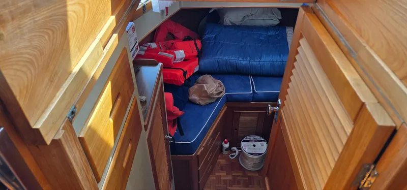Grand Finale Yacht Photos Pics Cozy cabin interior of 1991 Grand Banks 36 Classic with wooden finishes and blue bedding.