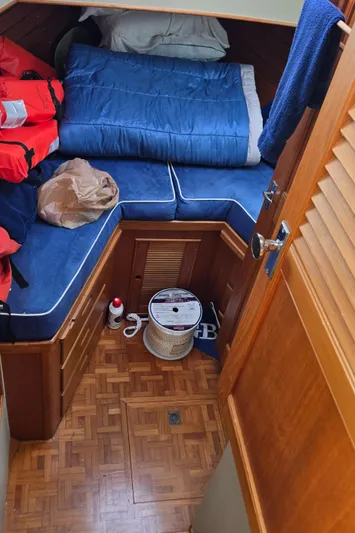 Grand Finale Yacht Photos Pics Cozy cabin interior of 1991 Grand Banks 36 Classic with blue bedding and wooden flooring.