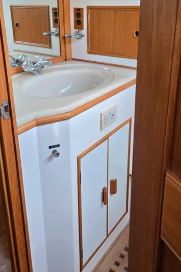 Grand Finale Yacht Photos Pics Bathroom sink area on a 1991 Grand Banks 36 Classic yacht, featuring wood accents and cabinetry.