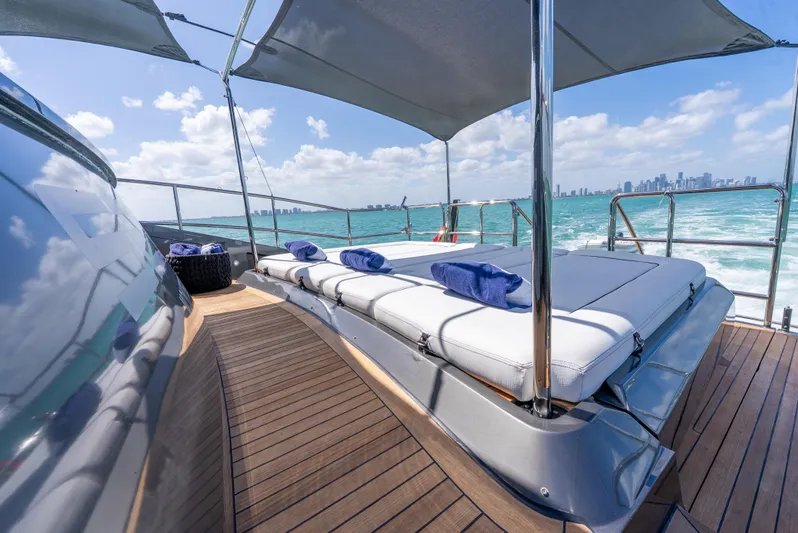  Yacht Photos Pics Luxurious Palmer Johnson 120 yacht deck with sun loungers, ocean view, and city skyline in background.