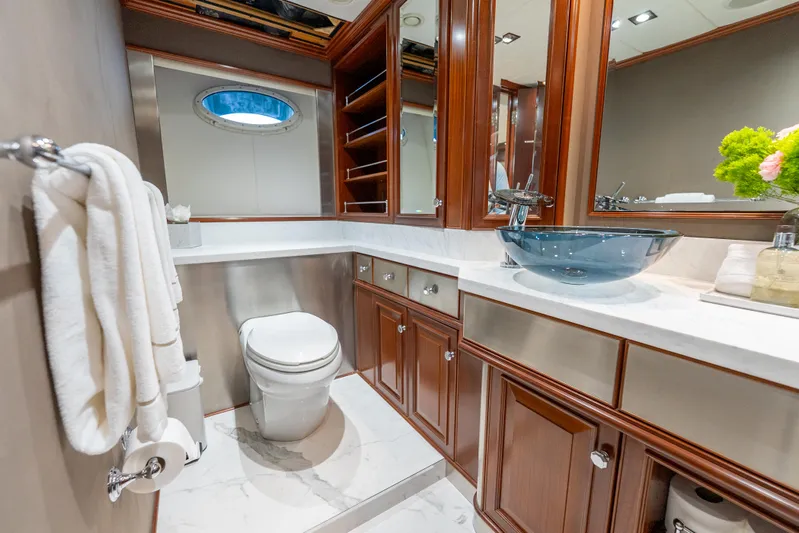  Yacht Photos Pics Luxurious yacht bathroom with wood cabinetry, glass sink, and modern fixtures on a 2003 Palmer Johnson 120.