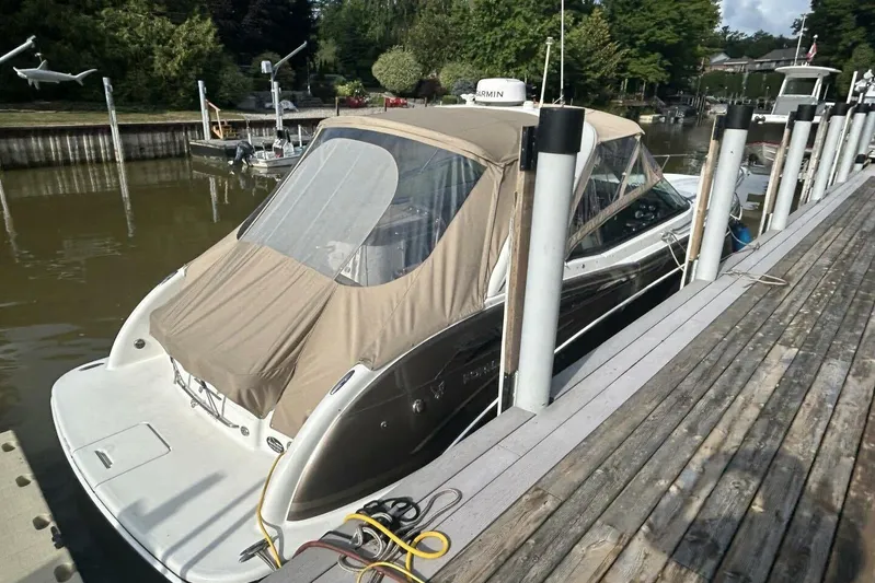  Yacht Photos Pics 2016 Formula 350 Sunsport boat docked, covered with beige canopy, surrounded by water and greenery.