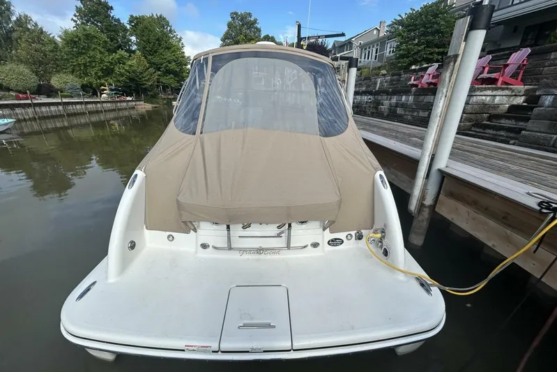  Yacht Photos Pics 2016 Formula 350 Sunsport boat docked, covered with beige canopy, surrounded by calm water.
