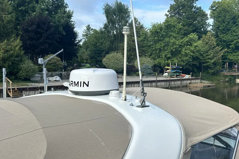  Yacht Photos Pics 2016 Formula 350 Sunsport boat with Garmin equipment, docked near lush greenery.