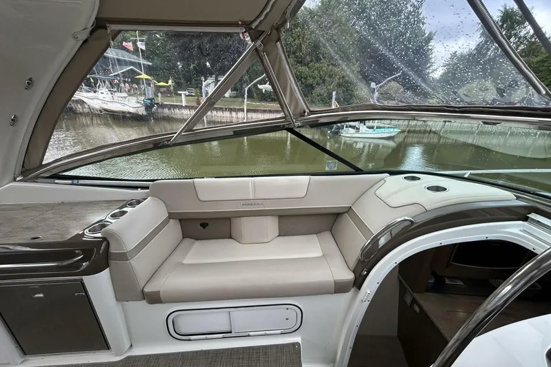  Yacht Photos Pics 2016 Formula 350 Sunsport boat interior with beige seating and cup holders, docked by a river.