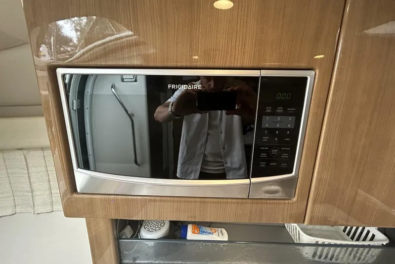  Yacht Photos Pics Frigidaire microwave in 2016 Formula 350 Sunsport boat interior, with wood paneling.