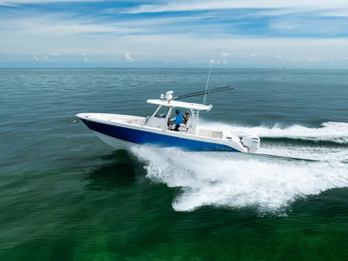  Yacht Photos Pics 2019 Everglades 335 Center Console boat cruising on open water, under a clear blue sky.