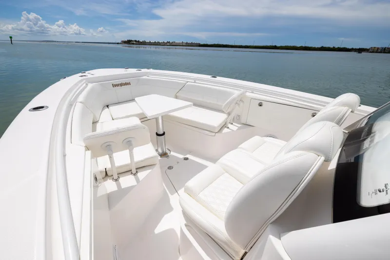  Yacht Photos Pics 2019 Everglades 335 Center Console boat with white seating and table on calm water.