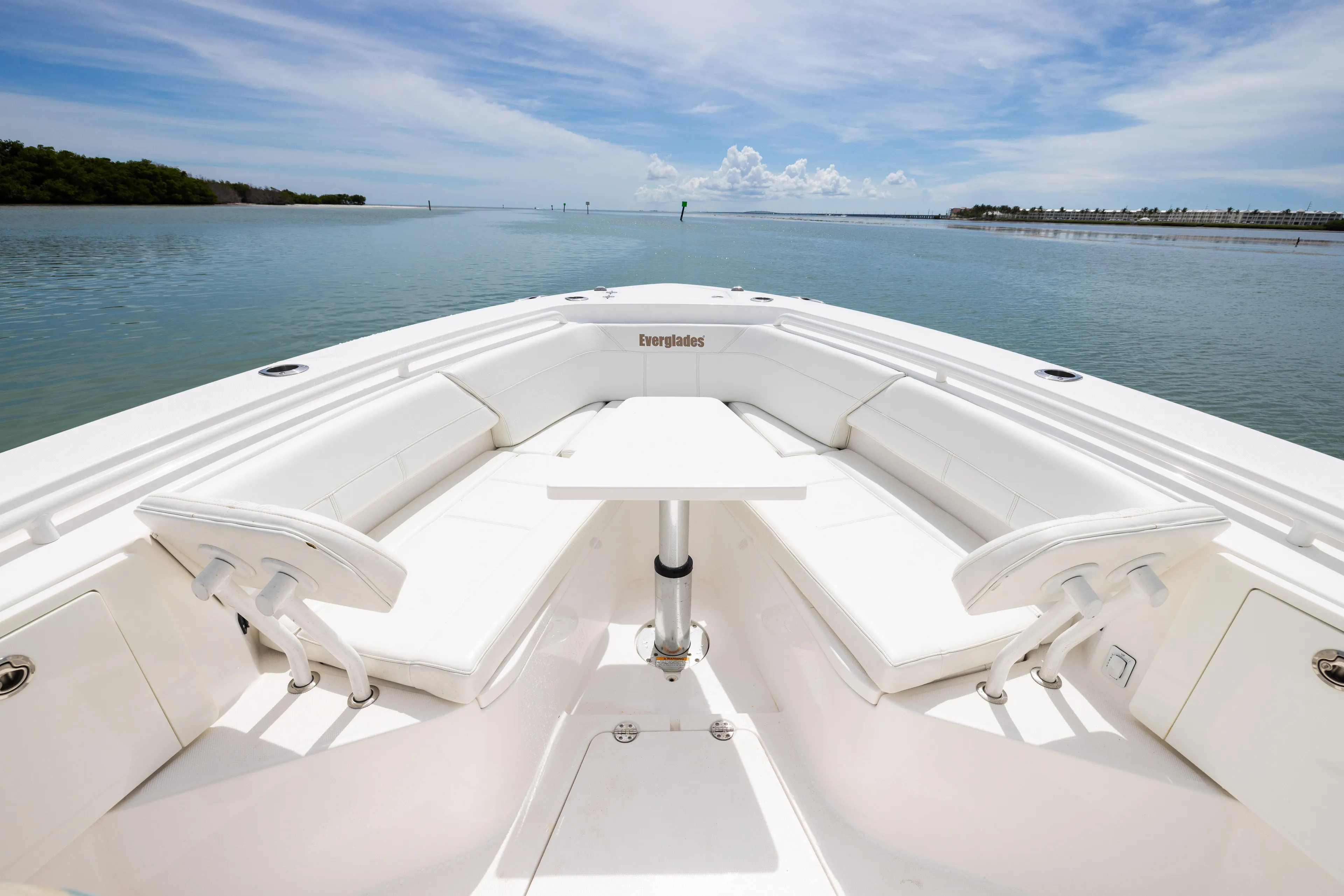  Yacht Photos Pics 2019 Everglades 335 Center Console boat with white seating and table on calm water.