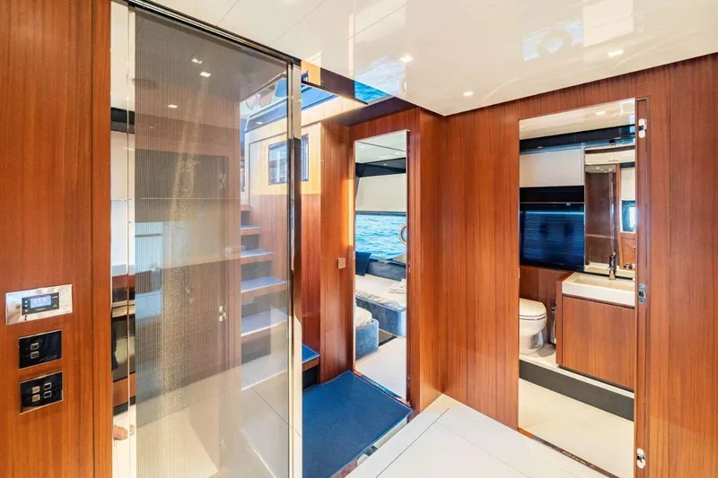  Yacht Photos Pics Luxurious interior of 2019 Riva 66 RIBELLE yacht with wood paneling and modern amenities.