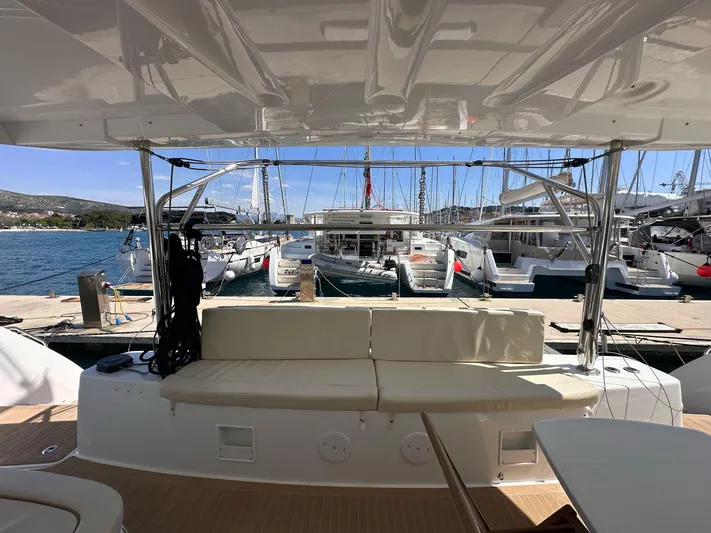 Gemini Yacht Photos Pics 2024 Lagoon 46 yacht interior with docked boats in marina background.