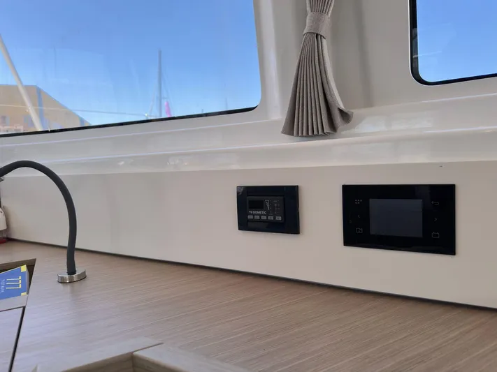 Gemini Yacht Photos Pics 2024 Lagoon 46 yacht interior with control panels and window view.