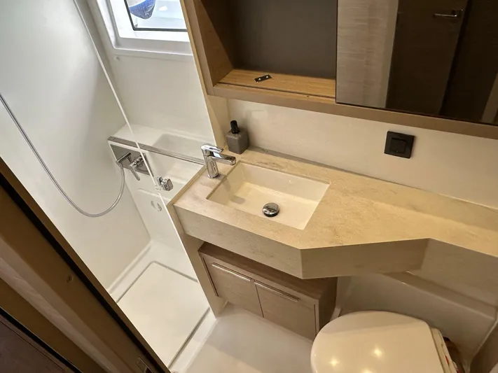 Gemini Yacht Photos Pics 2024 Lagoon 46 yacht bathroom with modern sink, shower, and storage.