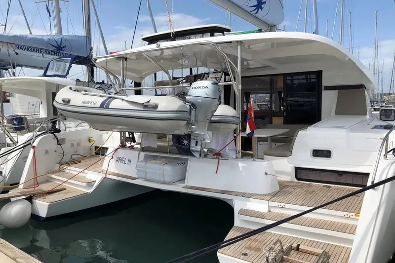 Ariel III Yacht Photos Pics 2018 Lagoon 42 catamaran docked with dinghy and Honda motor, featuring spacious deck.