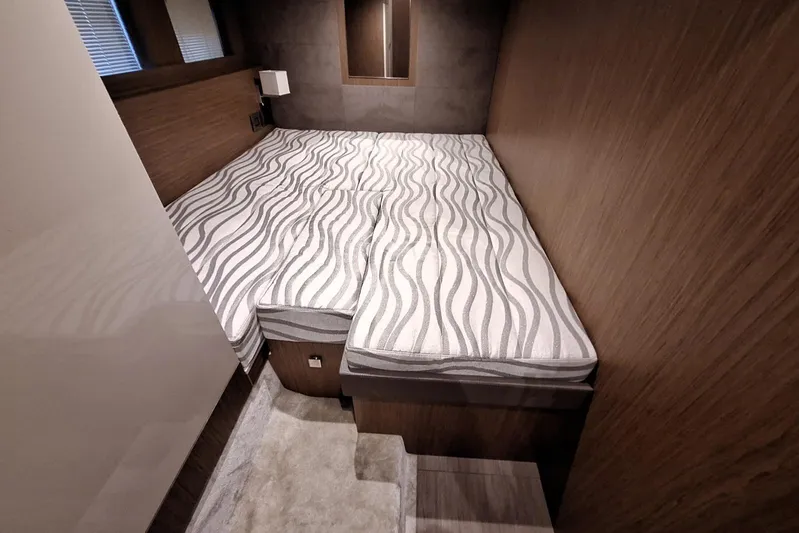  Yacht Photos Pics 2024 Cranchi T43 Eco Trawler cabin with modern bedding and wooden interior design.