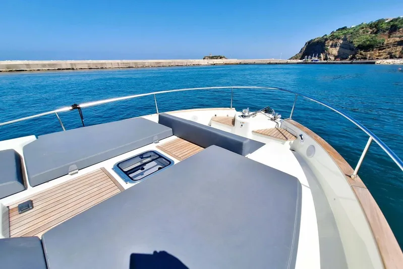 Yacht Photos Pics 2024 Cranchi T43 Eco Trawler on calm blue waters, featuring spacious deck and sunbathing area.