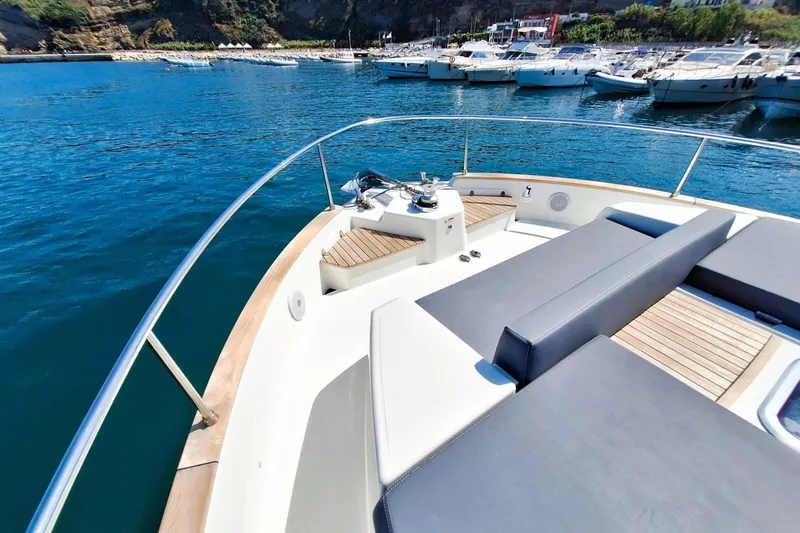  Yacht Photos Pics 2024 Cranchi T43 Eco Trawler's deck with seating, docked in a scenic marina.