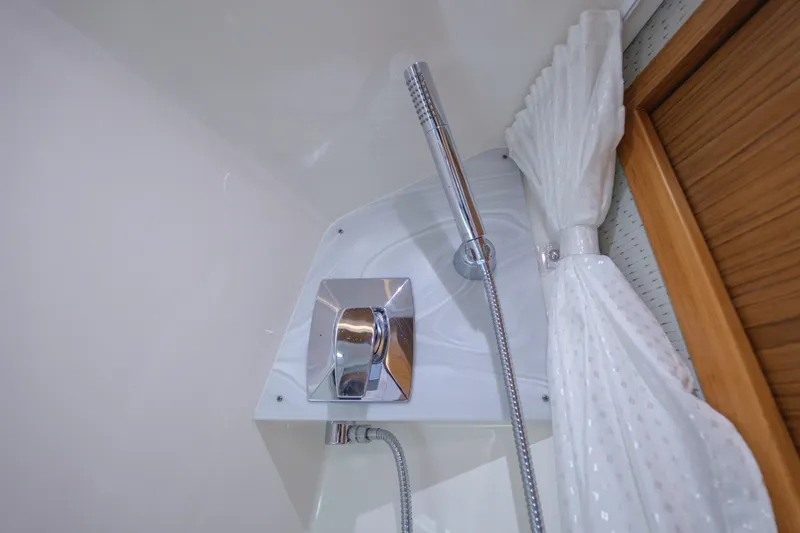  Yacht Photos Pics Shower area in 2020 Tiara Yachts 43 LS, featuring chrome fixtures and white curtain.