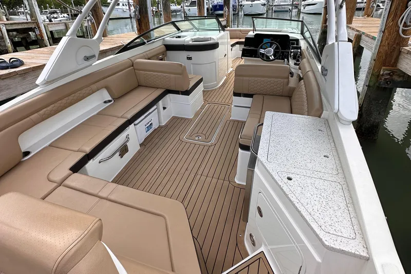  Yacht Photos Pics 2021 Sea Ray SDX 290 Outboard boat interior with tan seating and wood flooring.