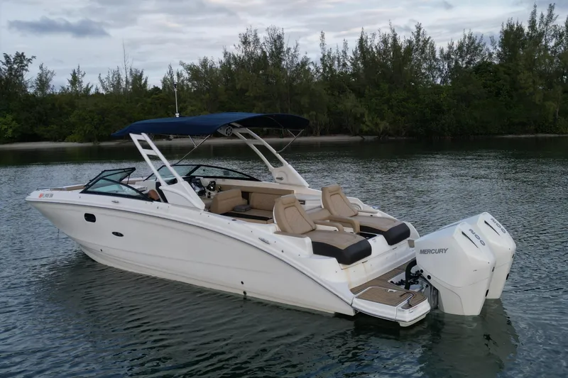  Yacht Photos Pics 2021 Sea Ray SDX 290 Outboard boat on calm water with lush greenery background.