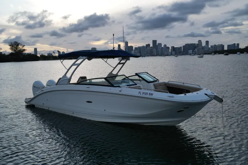  Yacht Photos Pics 2021 Sea Ray SDX 290 Outboard boat on water with city skyline background.