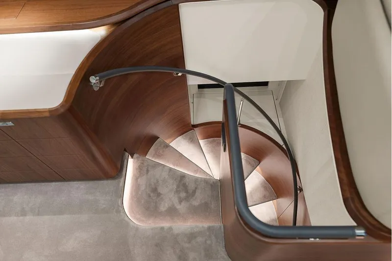 S72531 Yacht Photos Pics Elegant spiral staircase in 2025 Princess S72 yacht interior, featuring wood and modern design.