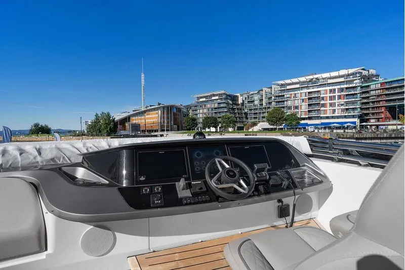 S72531 Yacht Photos Pics Helm of 2025 Princess S72 yacht with modern controls, docked near waterfront buildings.