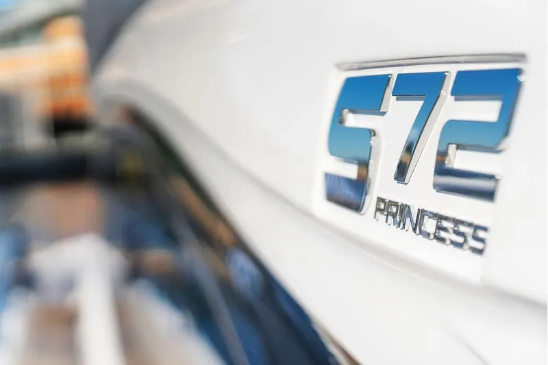 S72531 Yacht Photos Pics Close-up of 2025 Princess S72 yacht emblem on white surface.