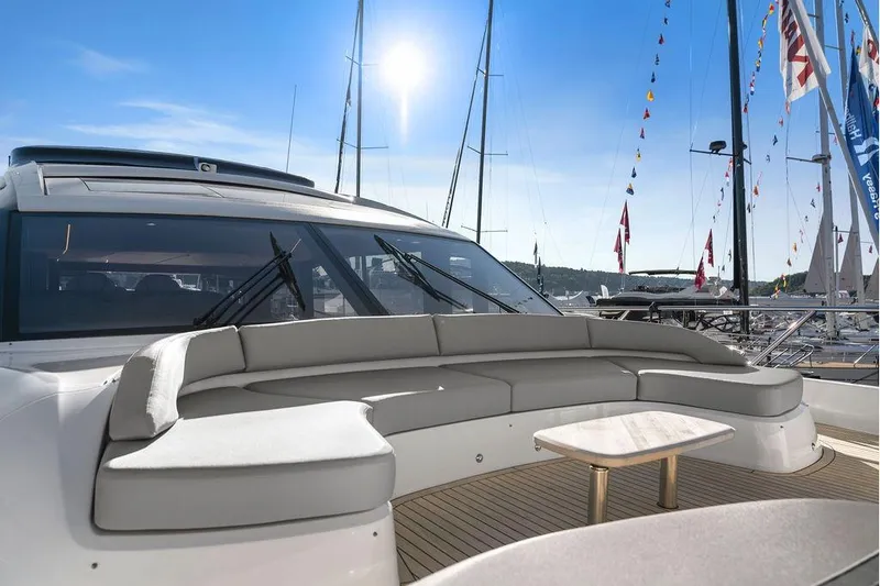 S72531 Yacht Photos Pics Luxurious 2025 Princess S72 yacht with elegant outdoor seating and table, docked under clear blue skies.