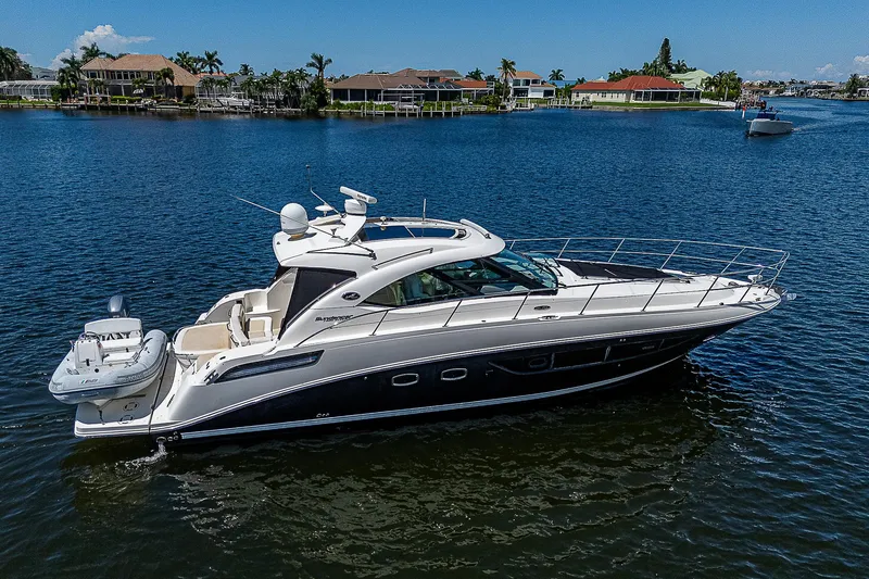  Yacht Photos Pics 2014 Sea Ray 470 Sundancer yacht on calm water, surrounded by waterfront homes.