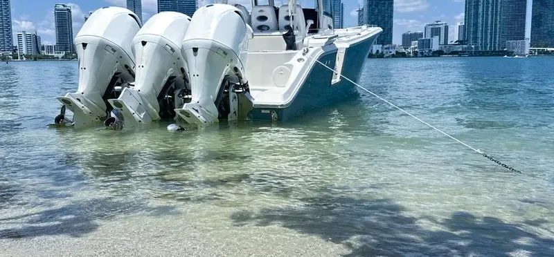  Yacht Photos Pics 2018 Cobia 344 Center Console boat anchored near city skyline.