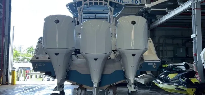  Yacht Photos Pics 2018 Cobia 344 Center Console boat with triple outboard engines in a storage facility.