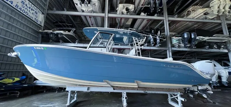  Yacht Photos Pics 2018 Cobia 344 Center Console boat in storage, blue hull, indoor facility.
