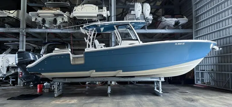  Yacht Photos Pics 2018 Cobia 344 Center Console boat in storage, blue hull, indoor facility.