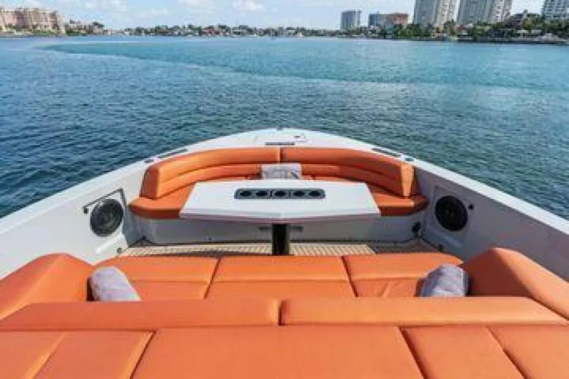 Incentivized Yacht Photos Pics Luxury Vanquish VQ58 yacht with orange seating, 2021 model, on serene water.