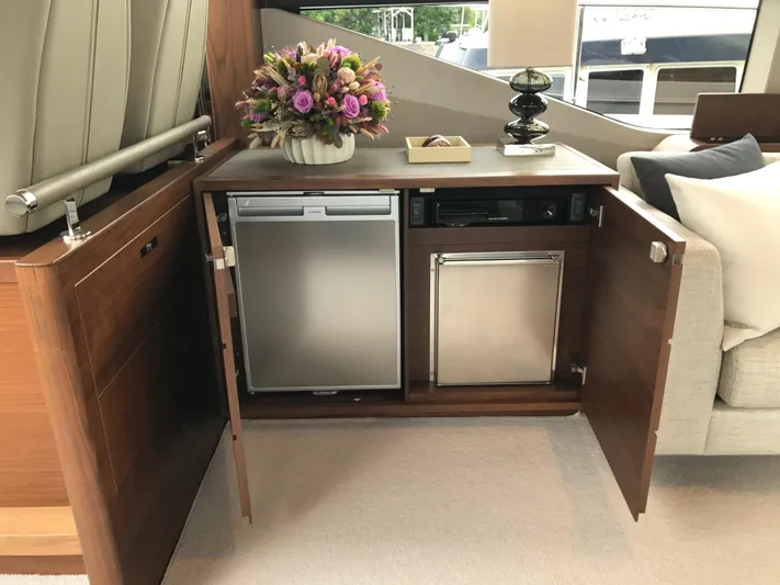  Yacht Photos Pics Luxury yacht interior with open cabinet, mini fridge, and floral arrangement. Princess 68, 2017 model.