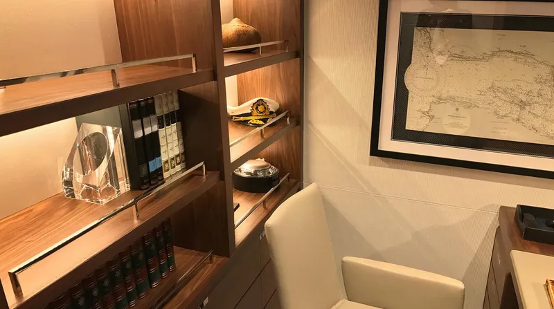  Yacht Photos Pics Luxurious yacht interior with wooden shelves, books, and framed map, Princess 68, 2017 model.