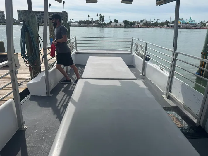 Mega Bite Yacht Photos Pics Open deck of 1986 Willard Marine Shark Boat, docked with a person standing.