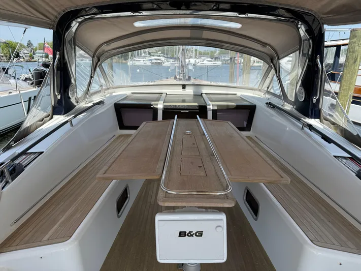 Blue Pearl Yacht Photos Pics Spacious cockpit of 2016 Beneteau Oceanis 60 sailboat with wooden seating and table.