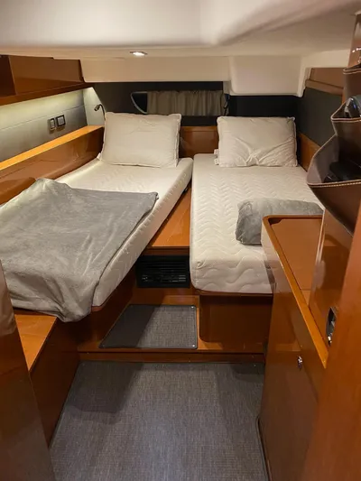 Blue Pearl Yacht Photos Pics Interior cabin of 2016 Beneteau Oceanis 60 yacht with twin beds and wooden furnishings.