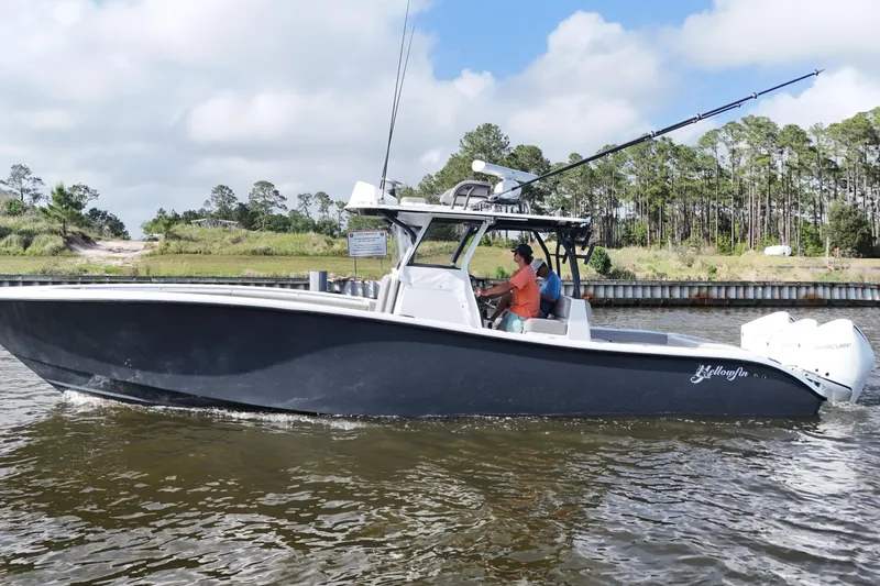 Warranty X Trailer Yacht Photos Pics 2022 Yellowfin 34 Offshore boat cruising on a river with two people onboard.