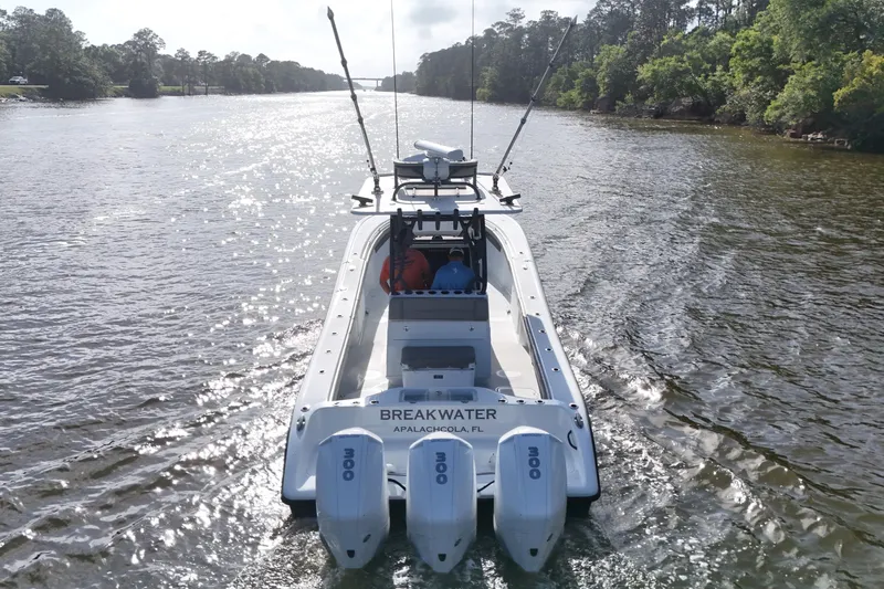 Warranty X Trailer Yacht Photos Pics 2022 Yellowfin 34 Offshore boat cruising on a scenic river.
