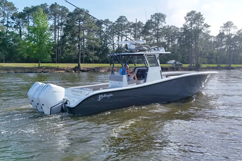 Warranty X Trailer Yacht Photos Pics 2022 Yellowfin 34 Offshore boat cruising on a lake with trees in the background.