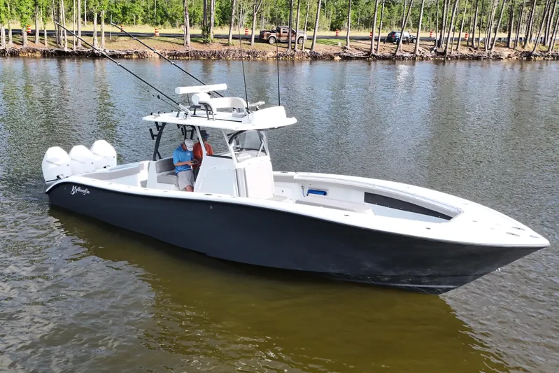 Warranty X Trailer Yacht Photos Pics 2022 Yellowfin 34 Offshore boat on calm water, surrounded by trees.