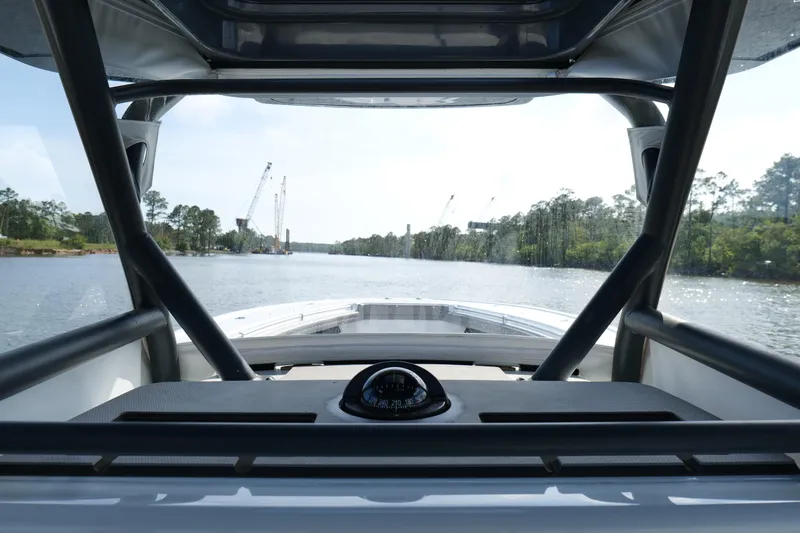 Warranty X Trailer Yacht Photos Pics 2022 Yellowfin 34 Offshore boat navigating a scenic river with cranes in the background.